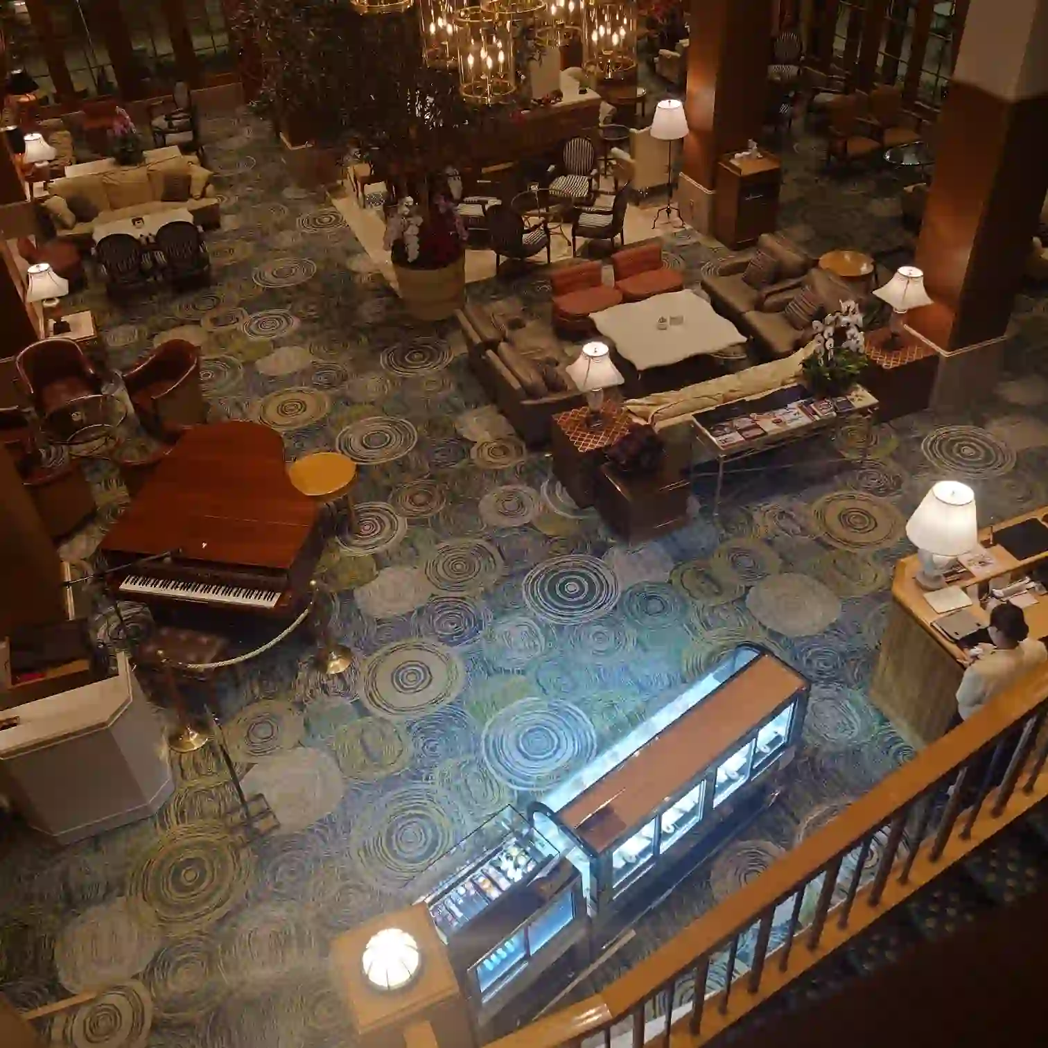 グランドエクシブ軽井沢のラウンジ「ミルティーユ」を階段上から見下ろした眺め（高い天井とシャンデリア、グランドピアノ）