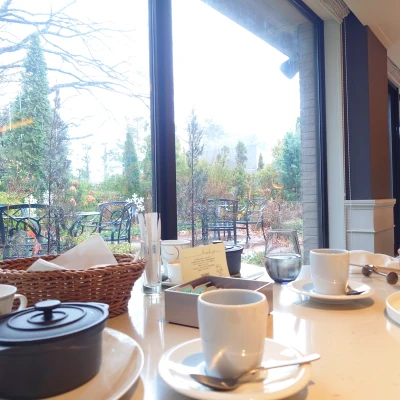 ルッチコーレ朝食テーブル　窓の外に軽井沢の庭とテラス席　カップと小鍋が並ぶ