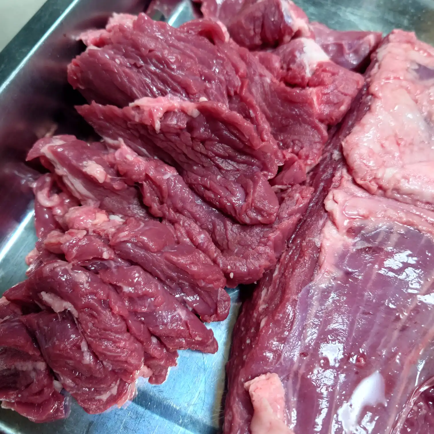 コストコのリブキャップ（かぶり）を筋に沿って切り分けた様子　赤身と脂身の塊が分かれている下処理工程