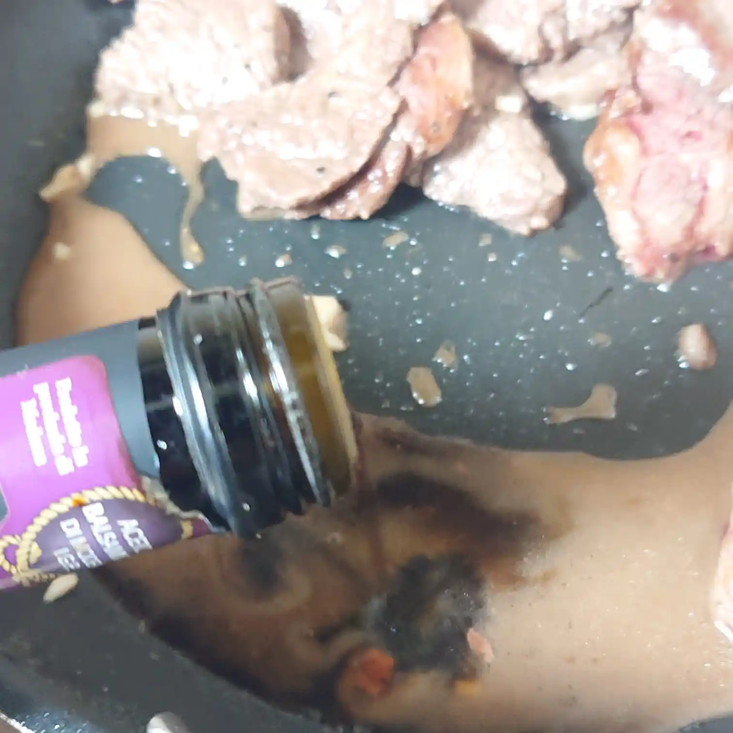 焼いたリブキャップの旨味が残るフライパンにバルサミコ酢を入れてソースを作る工程　肉汁と合わせて煮詰める瞬間