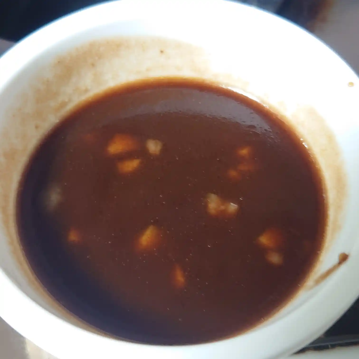 肉汁と調味料で作ったタリアータ用ソース　刻みニンニクが浮かぶ濃厚なソースのアップ