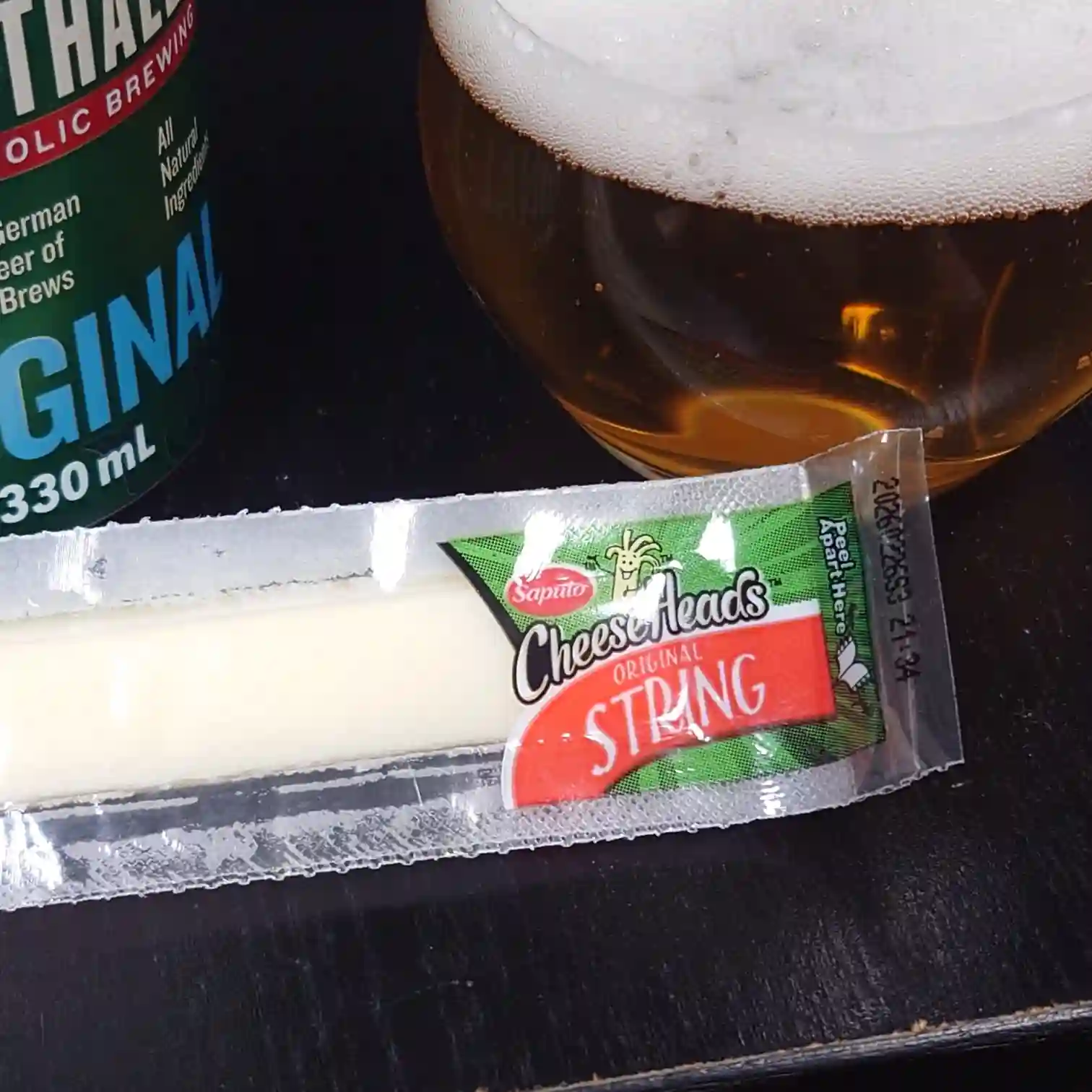 クラウスタウラー（ノンアル）と泡の立つグラス　つまみにストリングチーズを添えた晩酌セット