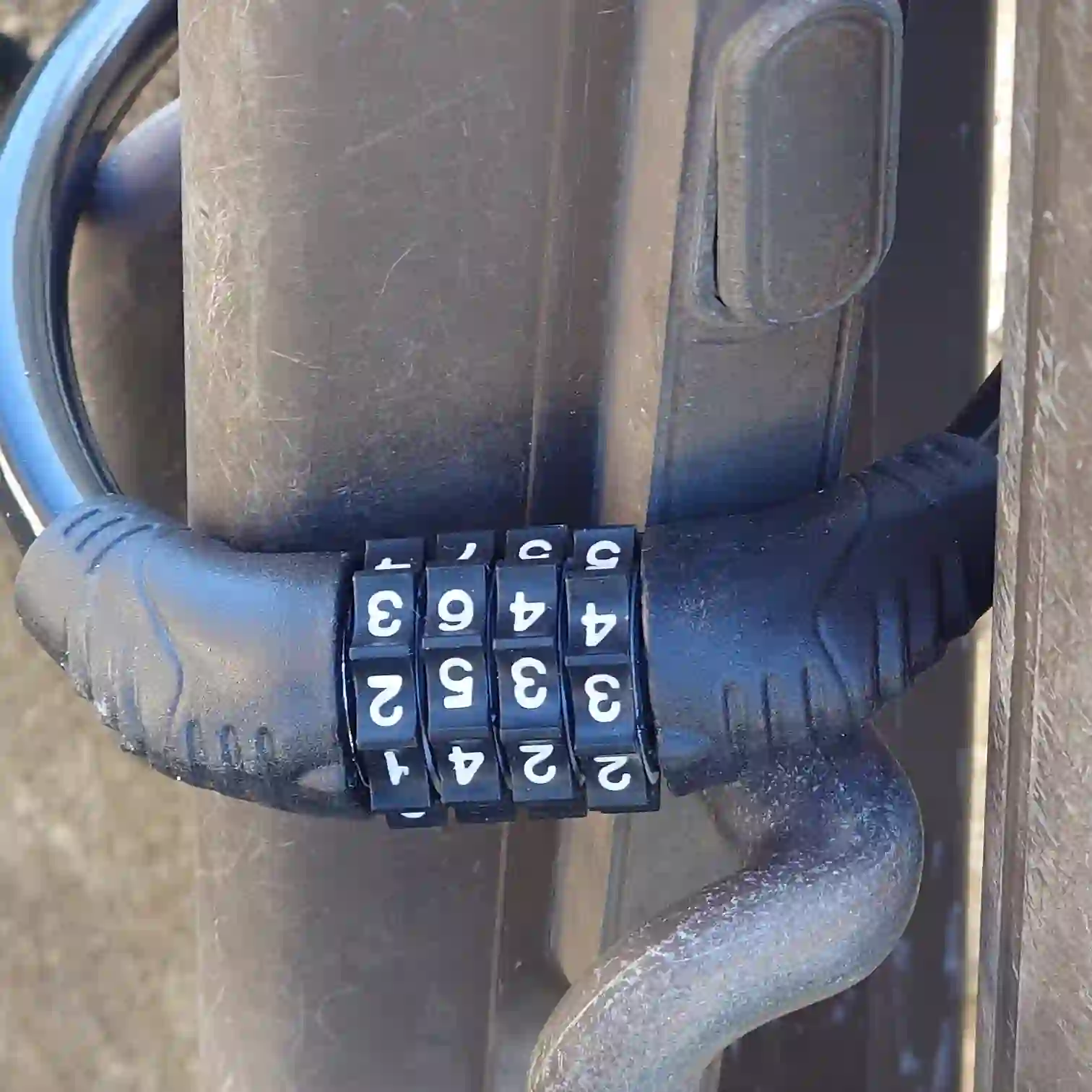 フェンスに取り付けた小型のダイヤル式ワイヤーロック　固定した状態のアップ