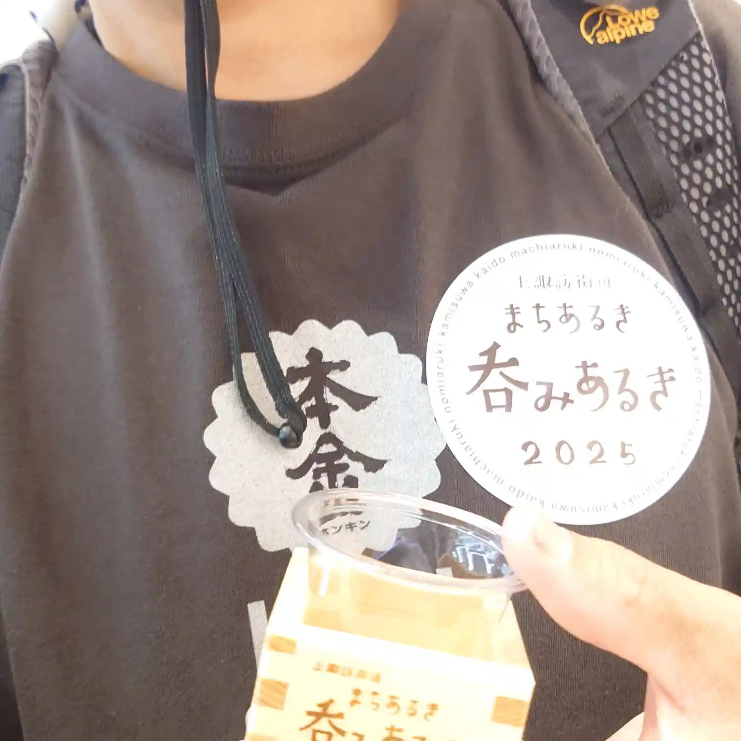 諏訪の飲み歩きイベント参加者が手にする、首掛けの参加証と専用のお猪口