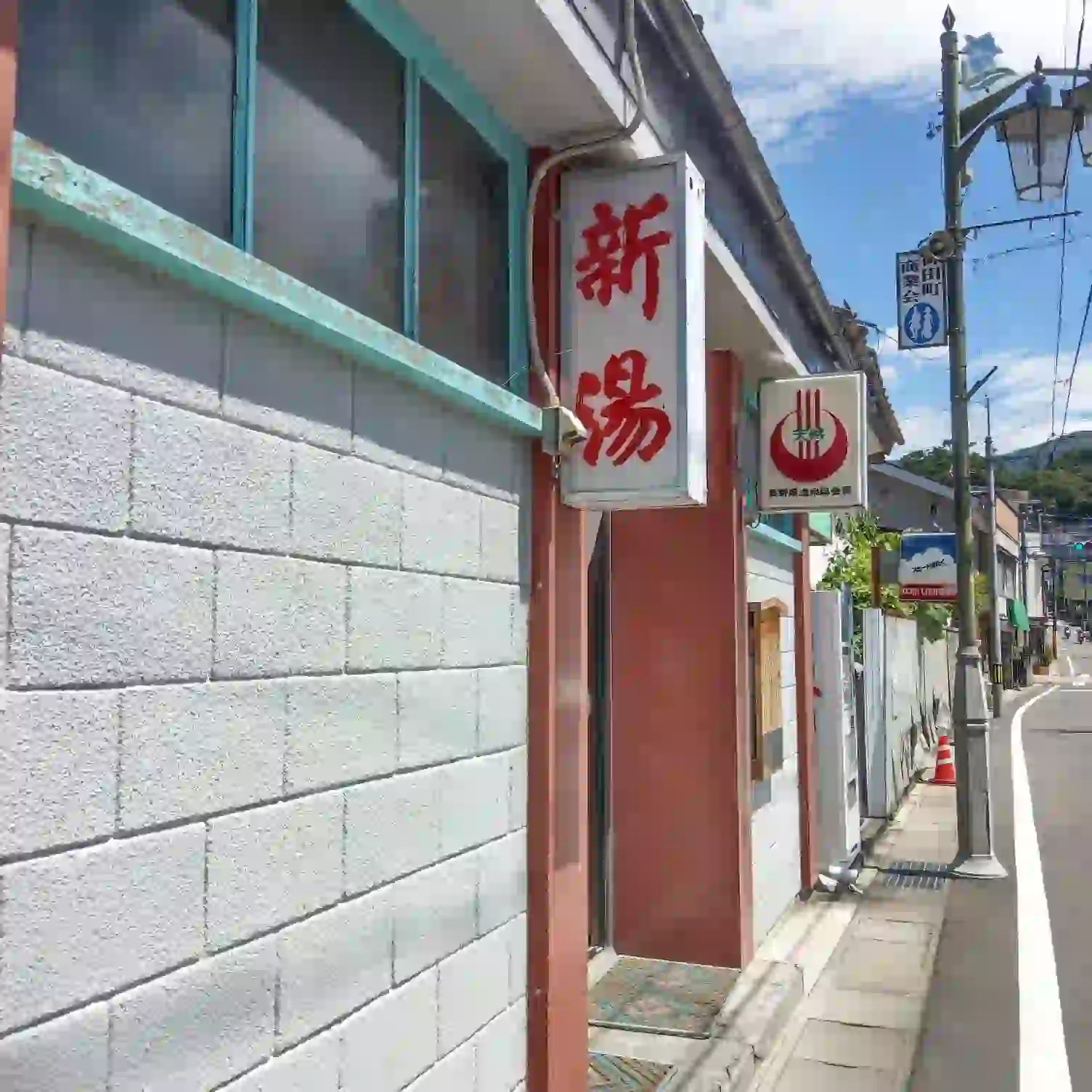 下諏訪温泉の共同浴場「新湯」の看板。落ち着いた温泉街の通りに馴染んでいる様子
