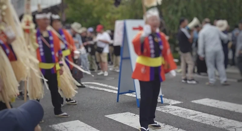 法被を着た諏訪木遣保存会の方々が、威勢よく木遣り唄を披露している場面