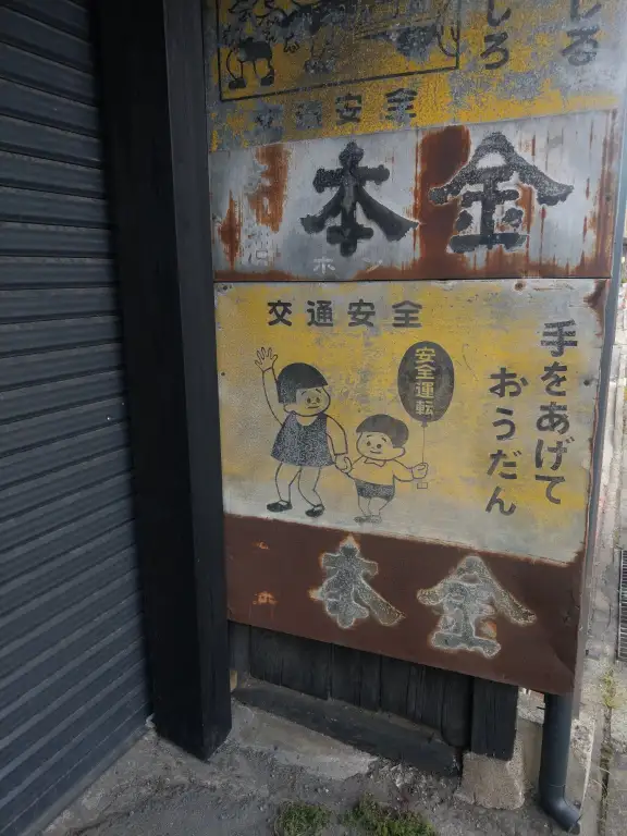 酒ぬのや本金の歴史を感じさせる、錆の浮いた渋い金属看板