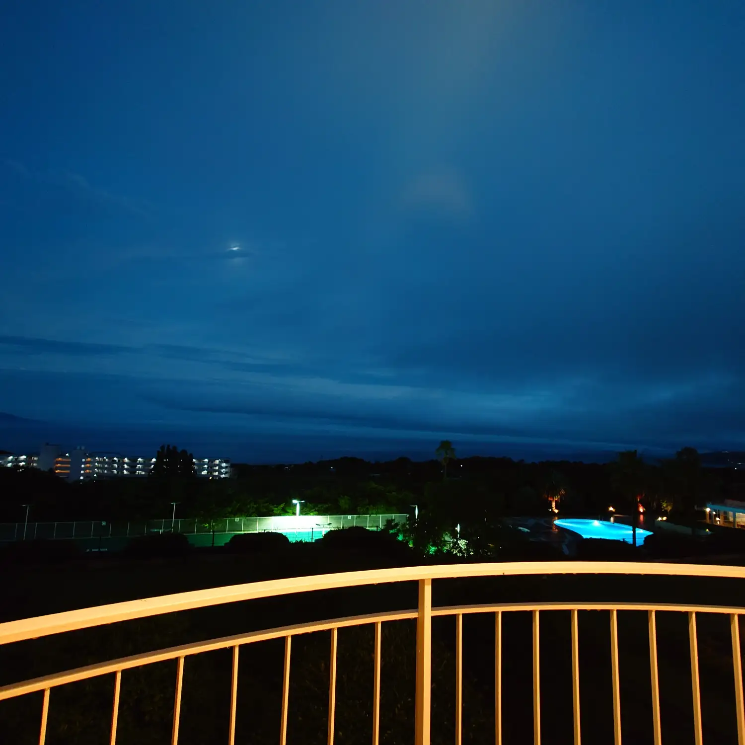 エクシブ伊豆客室テラスから眺める雨上がりの夜景と青く光るプール