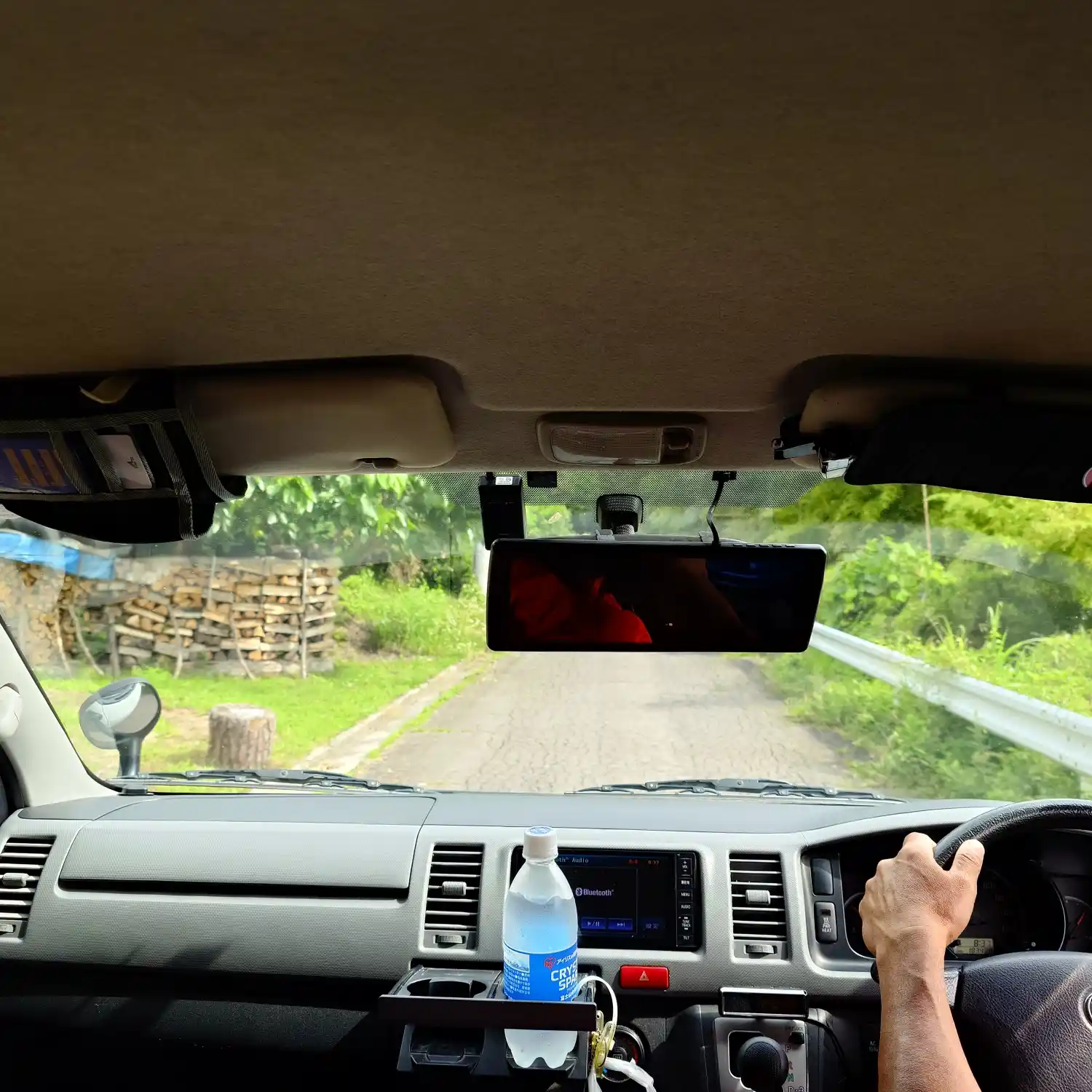 青木村の山へ続く狭く急な道を登るパラグライダー送迎車