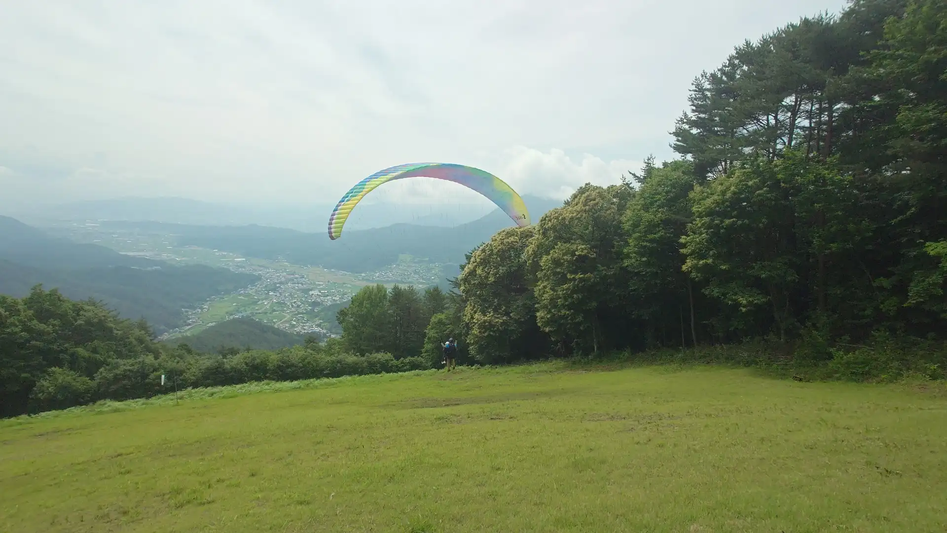 青木村の上空へ飛び出したカラフルなパラグライダー