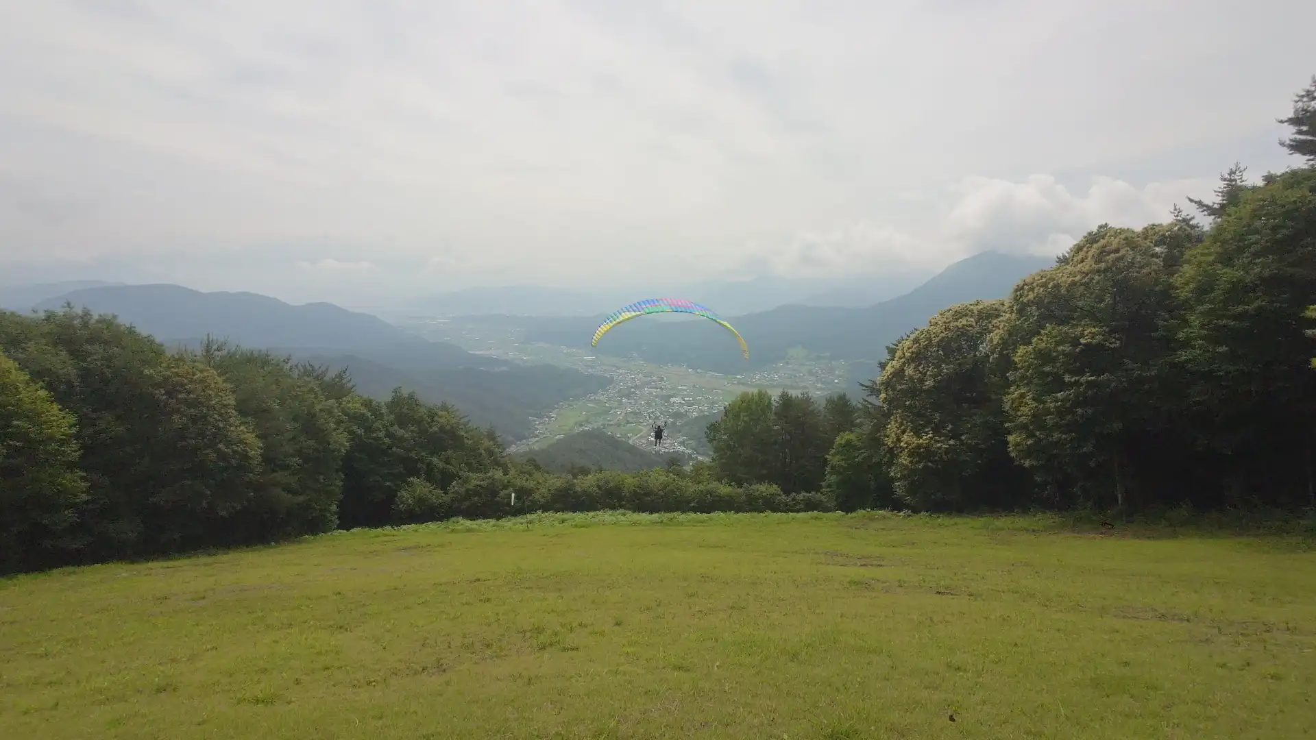 青木村の谷を見下ろしながら飛ぶタンデムパラグライダー