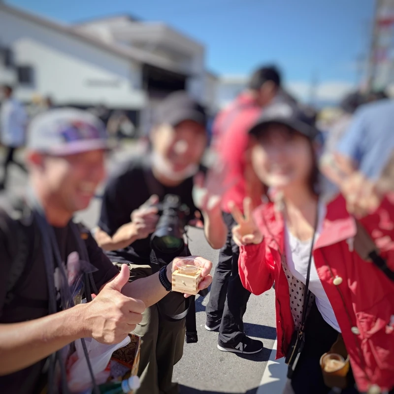 本金前で本格的なカメラを持つE-plus Webニュース担当者と出会った場面