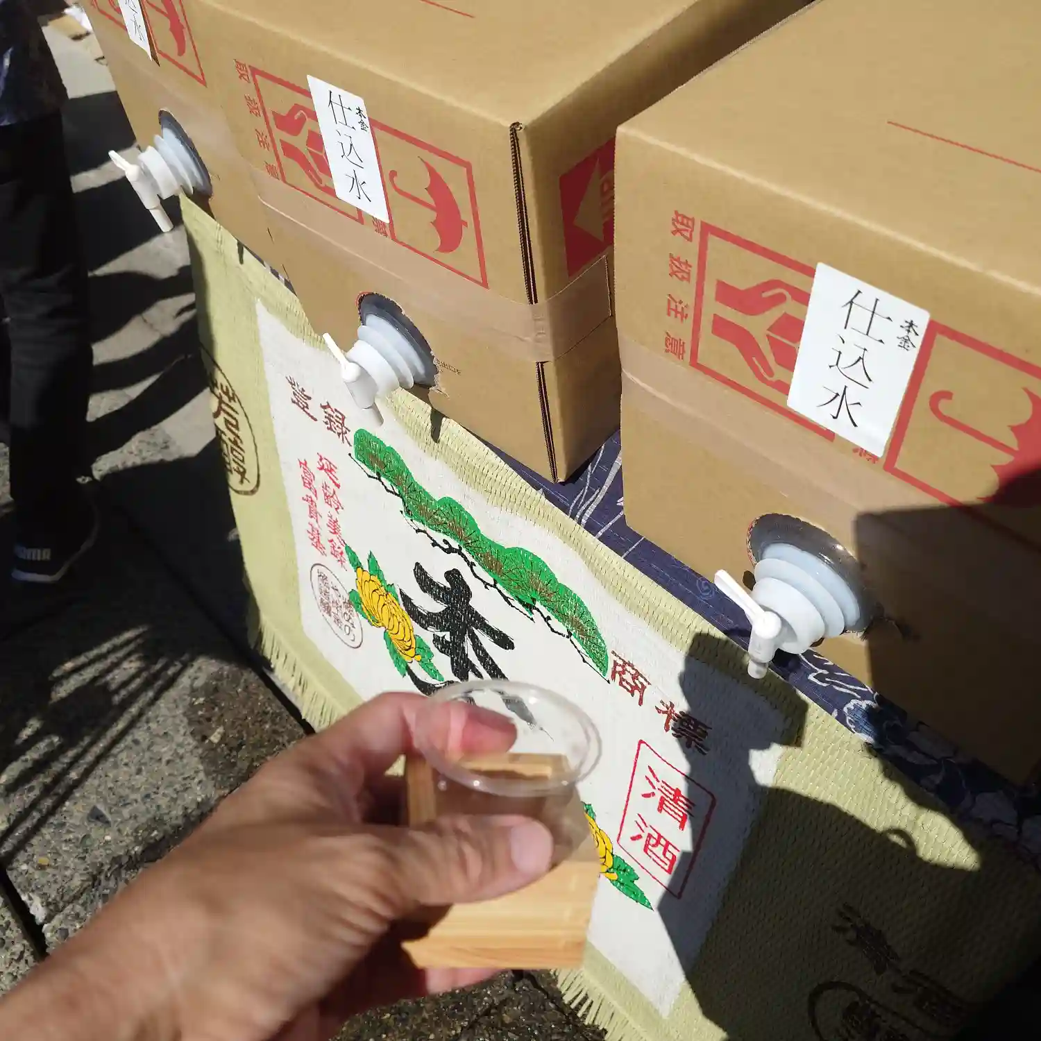 酒ぬのや本金酒造の仕込み水を枡でいただく場面